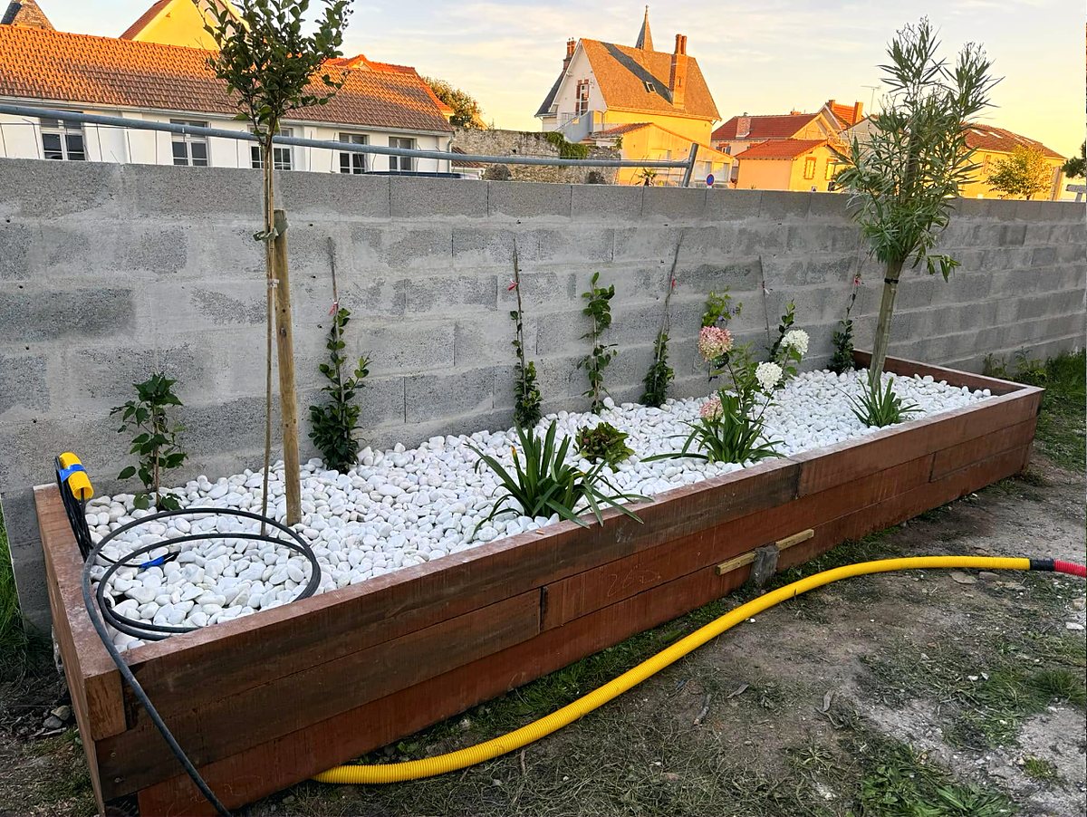 La même jardinière, plantée — Arbustes et vivaces, paillage minéral, arrosage automatique raccordé